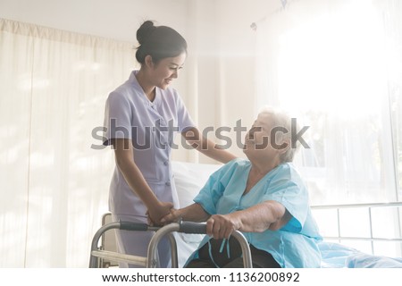 Asian young nurse supporting elderly patient disabled woman in using walker in hospital. Elderly patient care and health lifestyle, medical concept.
 Royalty-Free Stock Photo #1136200892