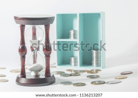 Time is money. The concept of accumulation of money, deposit. Hourglass and coins.