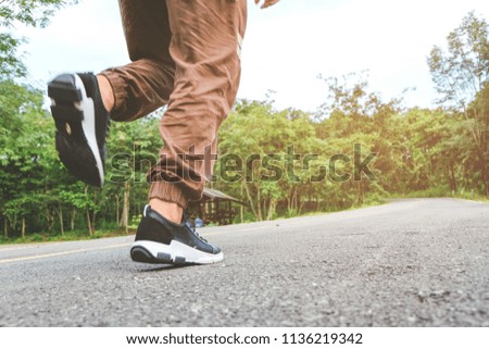 Runner athlete standing on road towards sun. Concept of new start, travel, freedom etc. Close up cropped low angle photo of shoe of athlete.