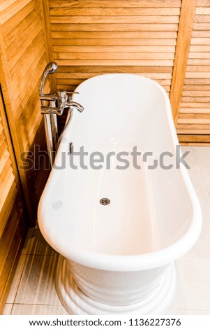 Wooden bathroom interior with white tub