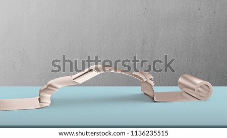 Metal roller sheet in sport car shape on table with concrete wall background, concept of energy saving.
