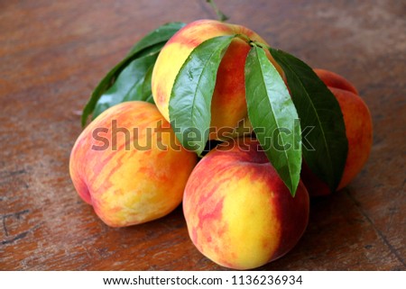
Peach fruit with leaf  on a wooden background. Royalty-Free Stock Photo #1136236934