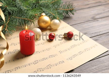 Composition with Christmas decorations and music sheets on table