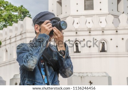 Traveling Asian male tourist backpackers taking photo in  Bangkok at Thailand on holidays