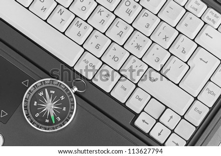 Computer keyboard and black compass on  notebook