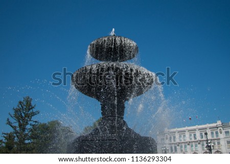 fountain in park on blue sky with cirrus clouds background