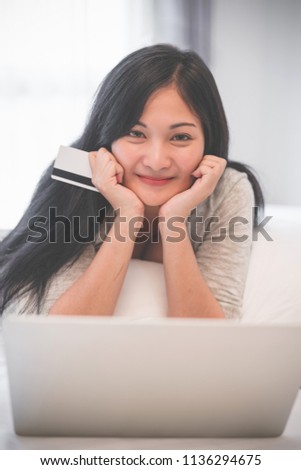 Young woman working on a laptop and uses credit card, bussiness and shopping concept.