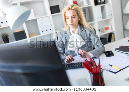 Young girl in office working with computer and documents.