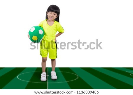 Kid holding soccer on Artificial field.