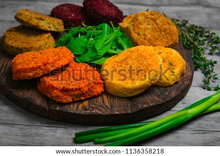 Vegetables patties (cutlets) for vegan burgers in bowl. Mix Vegetables stack fresh burgers. Spices for patties (cutlets) thyme, arugula. Gray wooden background. 