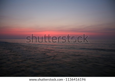Sunrise seen from a speeding rubber raft on a lake in southern Romania