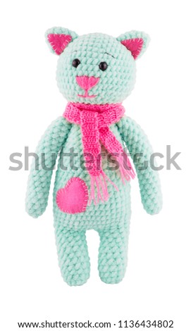 Plush crocheted cat with pink scarf. Soft toy knitted catIsolated on white. Toy cat