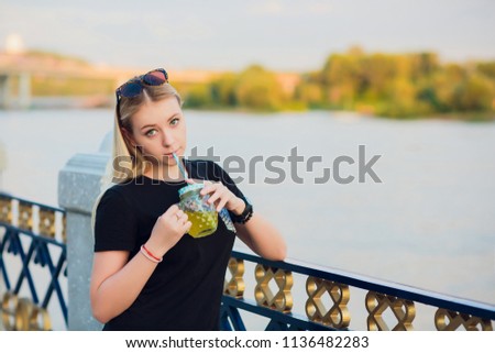 Pretty blonde girl with glass refreshing lemonade