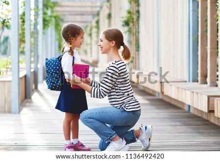 first day at school. mother leads a little child school girl in first grade
 Royalty-Free Stock Photo #1136492420