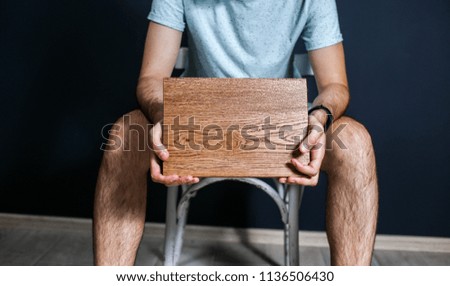 wooden board in the hands of a man, a place for an inscription. the concept of a social problem.