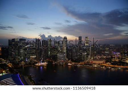 Modern architecture. Contemporary business city with high-rise buildings. Evening aerial view of skyscrapers in downtown Singapore under cloudy sky.