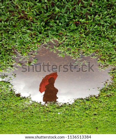 Reflection of person under umbrella