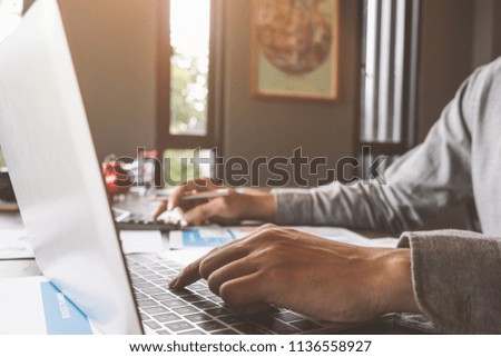 Business accounting, Businessman using computer laptop with document and caculator in office, Savings, finances and economy concept.
