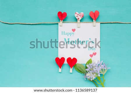 Happy Mother's day  card with red heart clip and flower on blue texture background, greeting card concept