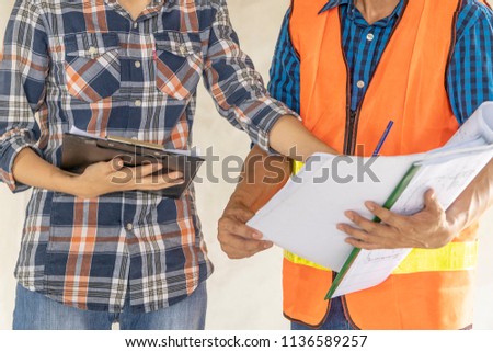 Civil engineer or architect and worker with safety helmet checking building ,engineering and architecture concept.Blue print is fake only for stock photo.