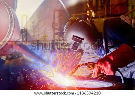 Ship building and ship repair industry Mig welder man in factory with protective equipment welding process and propeller background in shipyard Thailand