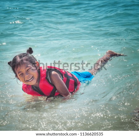 Asian babies are playing the sea happily.