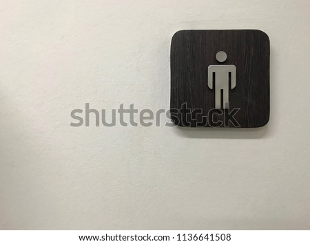Wooden bathroom sign on a white wall