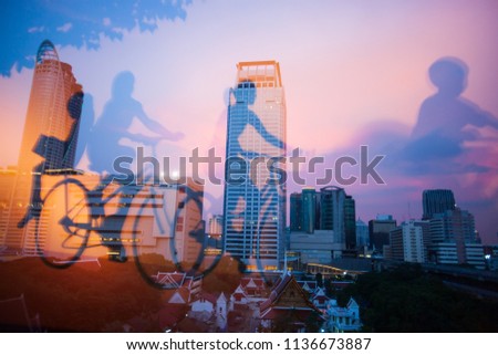 Mirror image, internal view of a book shop and mirrored picture of children ride bike. Bangkok City at twilight backgrounds. Beautiful sky. Abstract futuristic cityscape. Thailand. City concept.