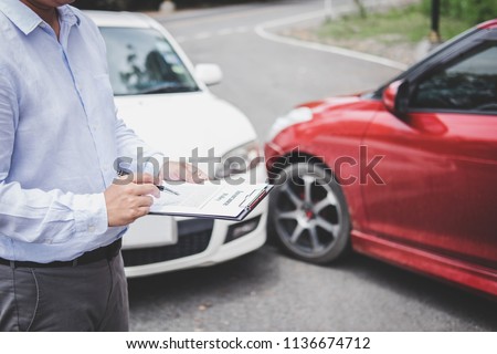 Traffic Accident and insurance concept, Insurance agent working on report form with car accident claim process.