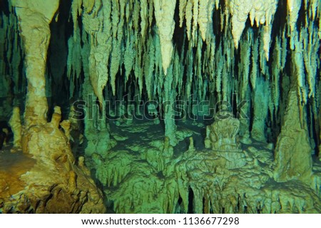 Cenote stalactites and columns. Limestone formation in the underwater cave. Photography from subterranean exploration.