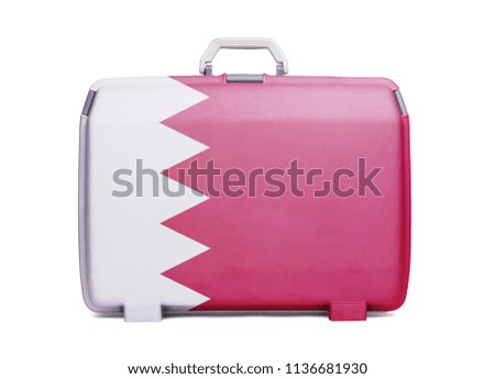 Used plastic suitcase with stains and scratches, printed with flag, Bahrain