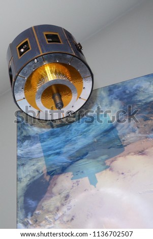 giant model materializing a satellite above the earth in space
