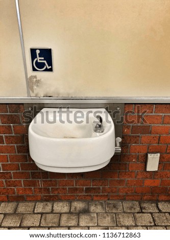 Old sink for disabled people (handicapped) at subway train station. Healthcare.
