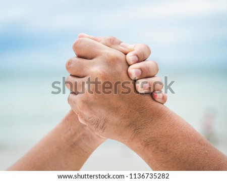 Close two holding Hands on sea bokeh background. Friendship, Helping Concept. Friendship Day.