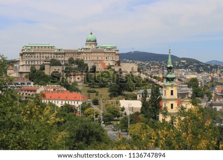 View of Buda Castle, the historic Royal Palace, an old church tower and the Buda Hills in Budapest 