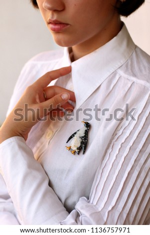 
Brooch penguin on a white shirt