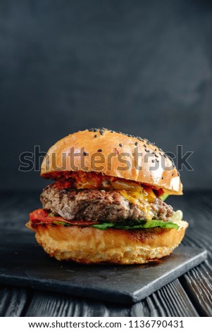 homemade  juicy burger on dark wooden board. Street food, fast food.