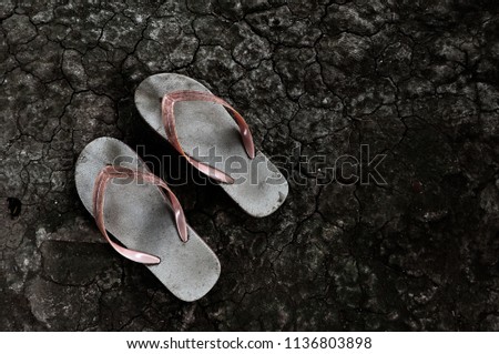 Old sandals One pair rests on an arid ground