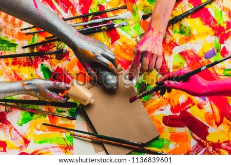 Creative project. Beautiful background. Art. The collective. Teambuilding. Four colored hands. Multi-color photo. Central composition. Filling the space. Work and fun.