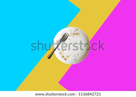 Empty plate with crumbs after eating on a bright colored background. The concept of the end of the holiday or celebration