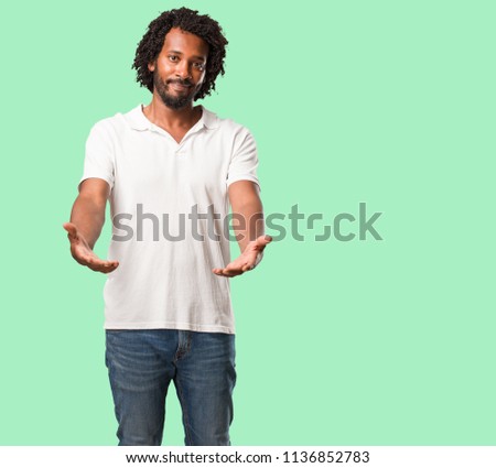 Handsome african american reaching out to greet someone or gesturing to help, happy and excited