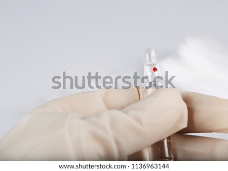 Glass ampule with medication in the hand of medical sister. Closeup