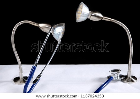 Energy saving-led lamps, headlamp,stethoscope on black and white background. Interest in action and behavior.