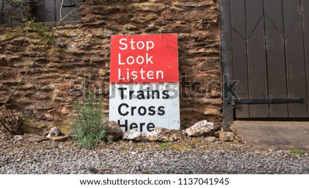 Stop Look and Listen sign for trains in front of old building
