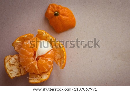 In a peeled mandarin, one spicy slice, an insider. An annoying blunder, an unpleasant surprise, a hidden evil. Top view, vignetting.