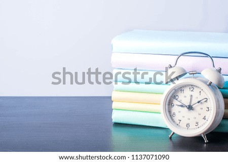 Alarm clock and book on light background with copy space. time management and the concept of reading books. reading a book for the final exam concept.