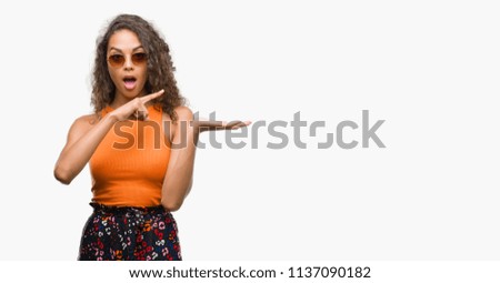 Young hispanic woman wearing summer outfit very happy pointing with hand and finger