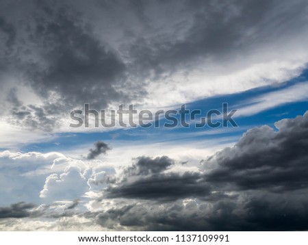 Dark blue grey layered clouds sky cover sun before raining.