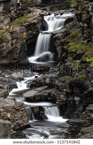 Beautiful cascade streaming in nature in Lyngenfjord, Norway.
