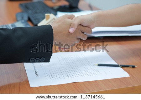Estate agent shaking hands with customer after signs home loan contract signature. successful agreement, housing purchase and insurance concepts